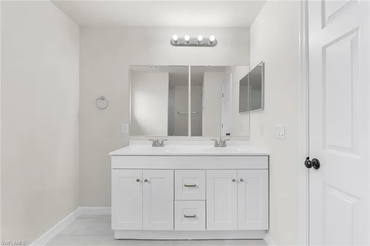 Bathroom with double vanity and tile patterned flooring