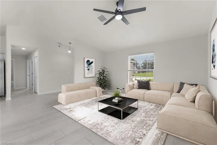 Living room featuring vaulted ceiling and ceiling fan