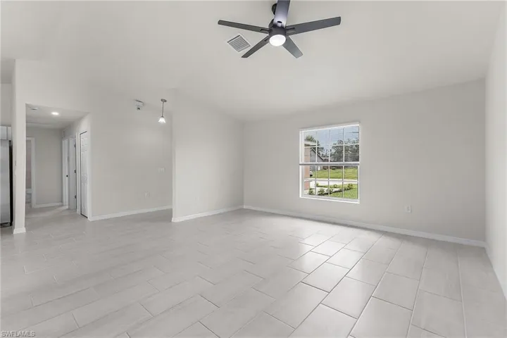Unfurnished room featuring light tile patterned floors and ceiling fan