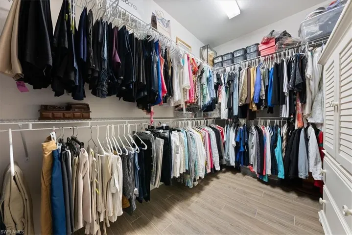 Walk in closet with wood plank tile floor