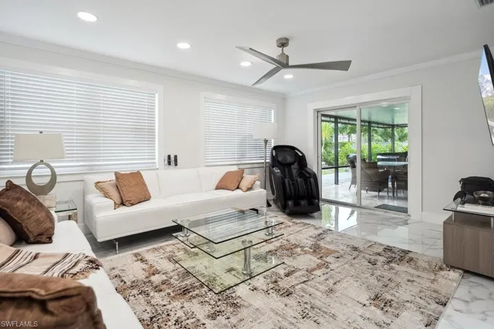Living room with ornamental molding, marble tiled flooring, a ceiling fan, and recessed lighting