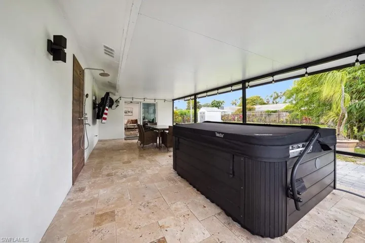 Sunroom featuring a jacuzzi and outdoor dining area