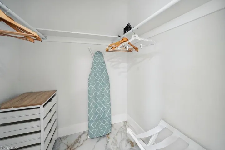Walk in closet with light marble finish floors