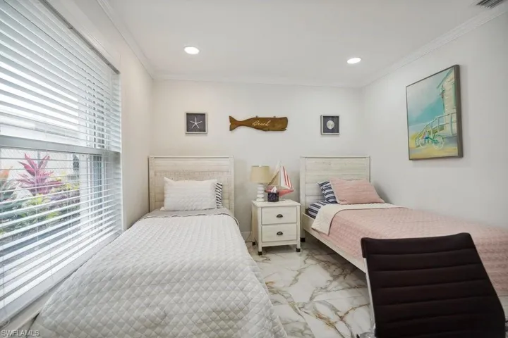 Bedroom featuring multiple windows, ornamental molding, light marble finish floors, and recessed lighting