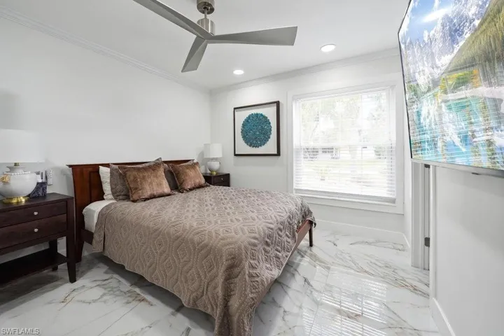 Bedroom with ornamental molding, light marble finish floors, recessed lighting, and ceiling fan