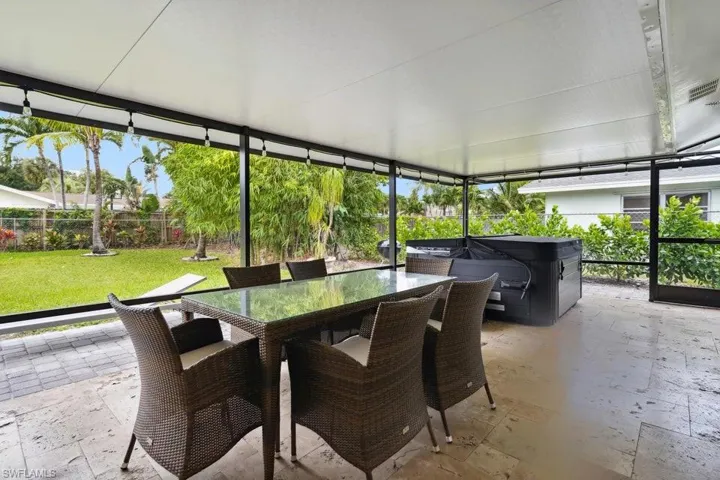 Sunroom / solarium featuring a hot tub and outdoor dining space
