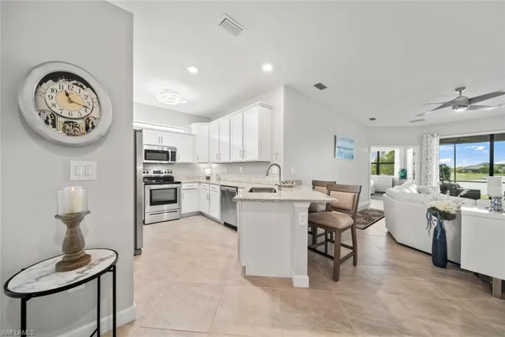 Kitchen featuring kitchen peninsula, a kitchen breakfast bar, stainless steel appliances, and 42" cabinetry