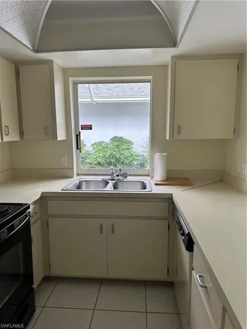 Kitchen with light countertops, light tile.