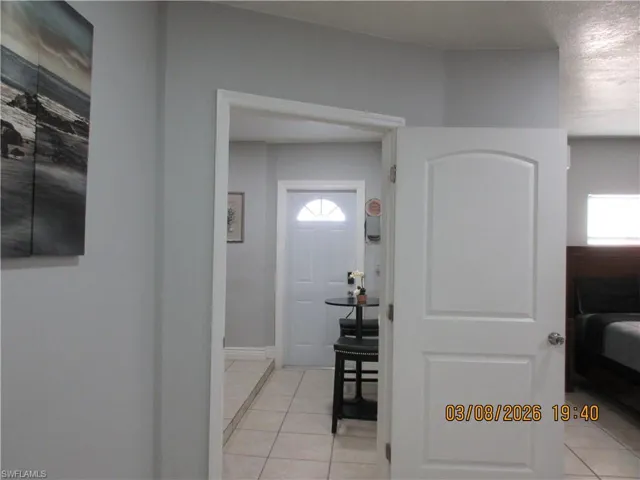 Foyer featuring light tile patterned floors and baseboards