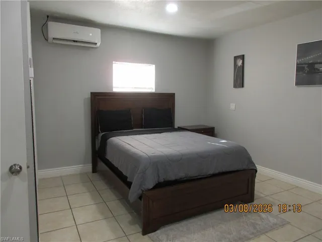 Bedroom featuring a wall mounted mini split and light tile patterned floors