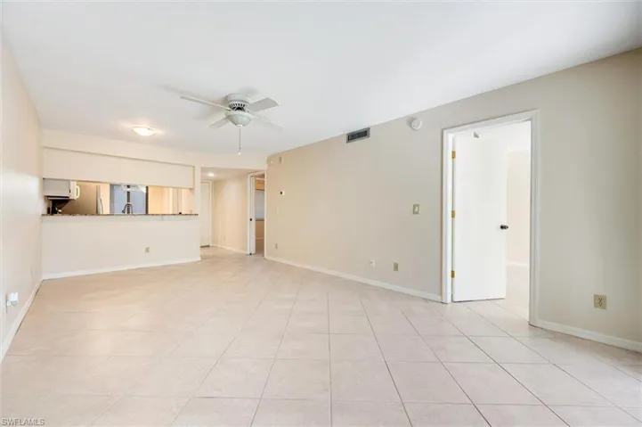Unfurnished living room featuring a ceiling fan and light tile patterned floors