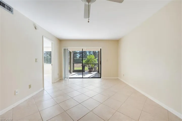 Empty room featuring ceiling fan and light tile patterned floors