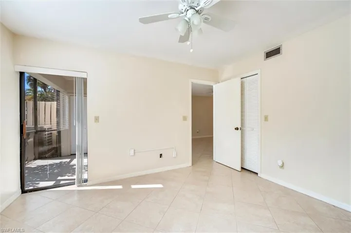 Empty room featuring ceiling fan and light tile patterned floors