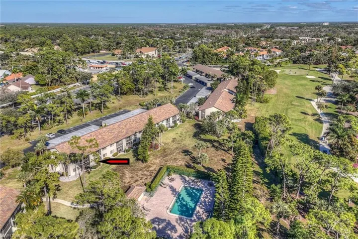 Aerial view of property and surrounding area with a golf club
