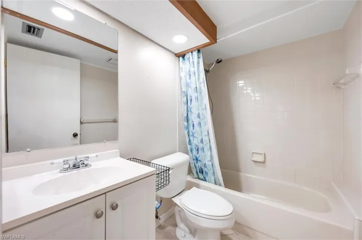Bathroom featuring vanity, shower / bath combo, and recessed lighting