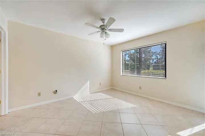 Unfurnished room with a ceiling fan and light tile patterned floors