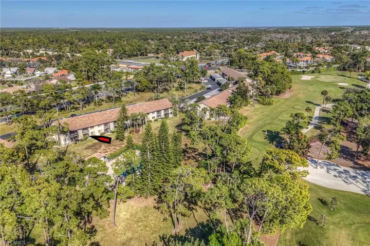 Aerial view of property and surrounding area with a golf club and nearby suburban area