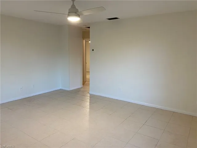 Spare room with ceiling fan and baseboards