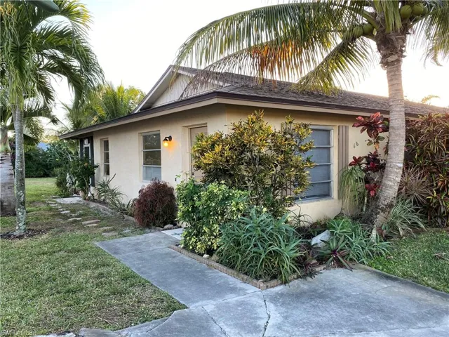 Doorway to property featuring stucco siding and a yard