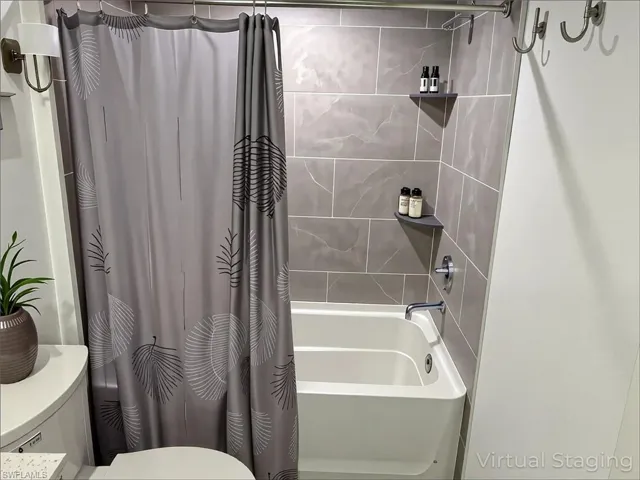 Full bath with shower / tub combo with curtain and toilet
