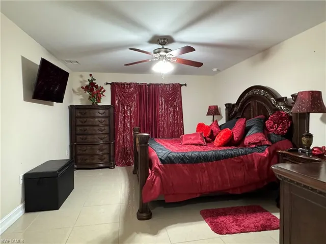 Bedroom featuring baseboards, visible vents, and ceiling fan