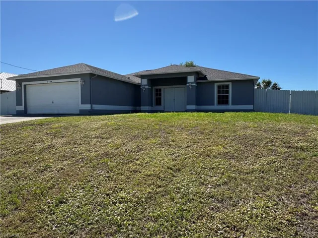 View of front of property with fence, stucco siding, a front lawn, concrete driveway, and a garage