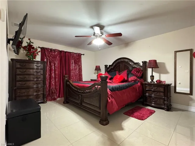Tiled bedroom with baseboards and a ceiling fan