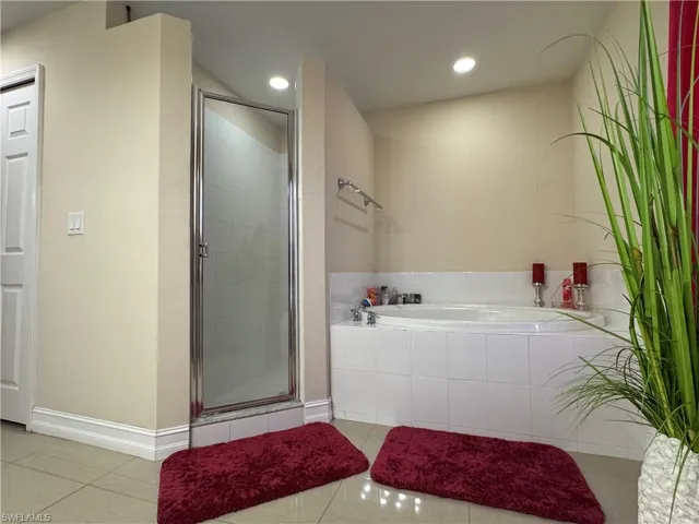 Full bathroom with tile patterned flooring, recessed lighting, a shower stall, and a garden tub