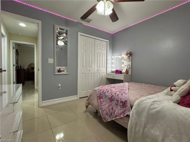 Bedroom featuring visible vents, a ceiling fan, a closet, light tile patterned flooring, and baseboards