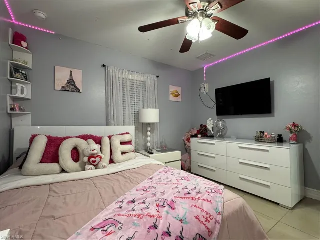 Bedroom with light tile patterned floors, visible vents, and a ceiling fan