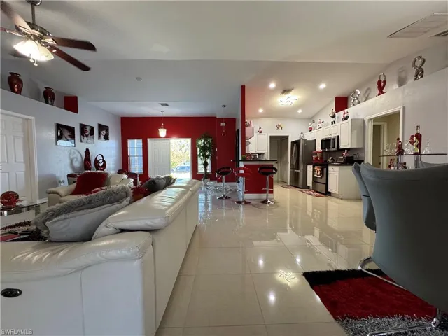 Living area with visible vents, ceiling fan, lofted ceiling, light tile patterned floors, and recessed lighting