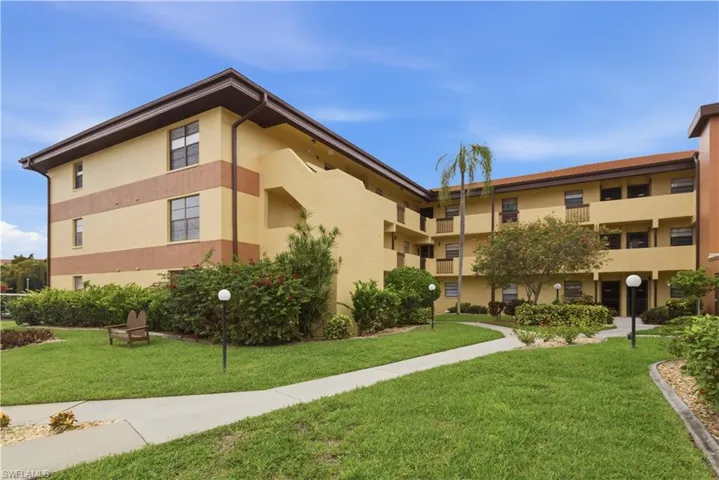Exterior residence with stucco finish, a tile roof, and multiple windows