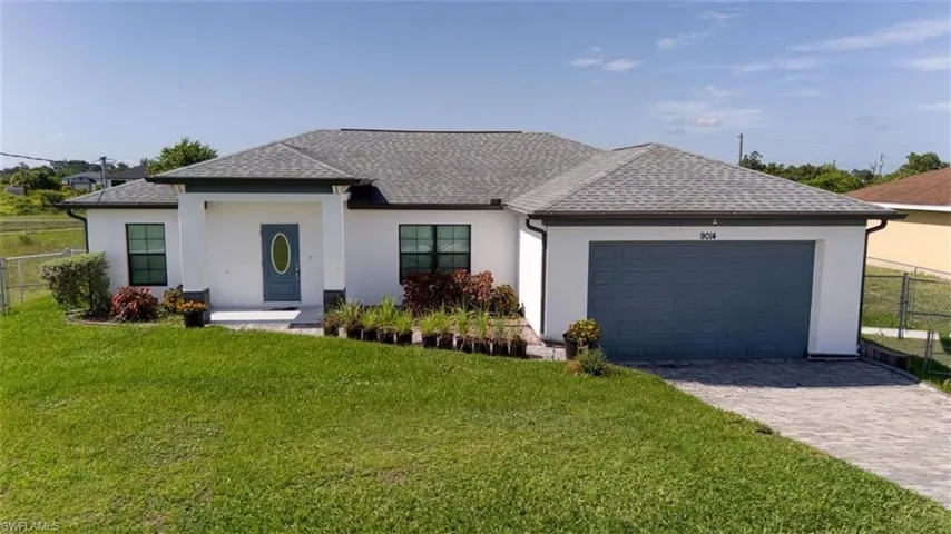 Contemporary single-story residence featuring a white stucco exterior, grey shingle roof, and a prominent blue garage door