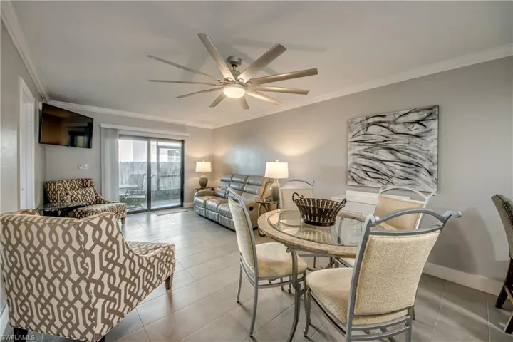 Tiled dining room featuring ornamental molding and a ceiling fan