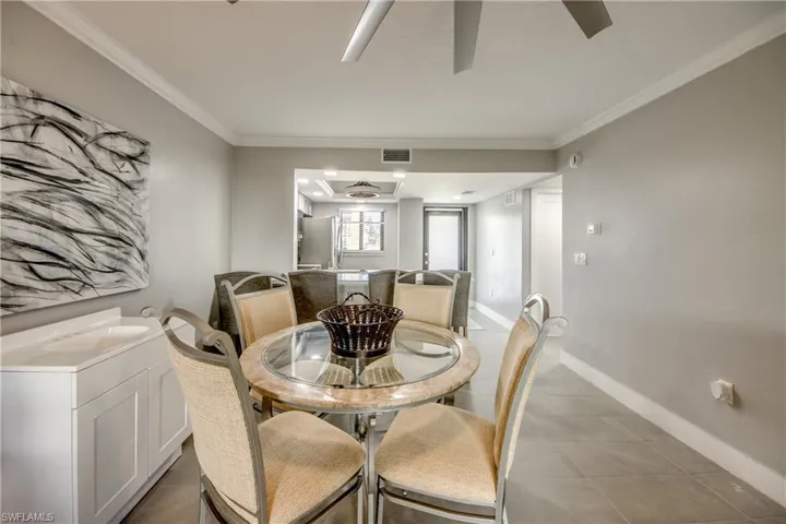 Dining area with ceiling fan and ornamental molding