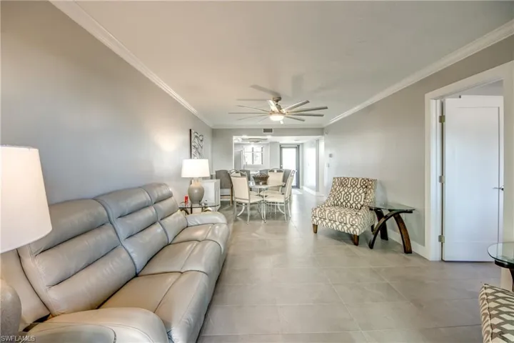 Living room with ceiling fan and ornamental molding