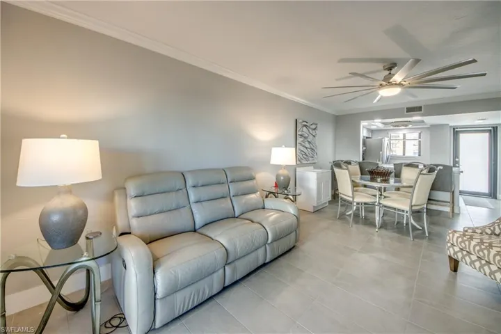 Living area featuring ornamental molding, ceiling fan, and tile patterned floors