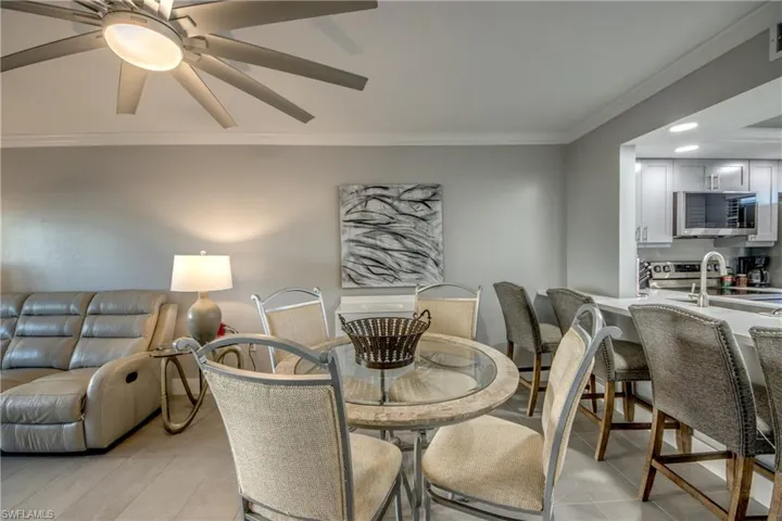 Dining room featuring crown molding, ceiling fan, and light tile patterned floors