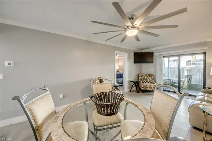 Dining area with crown molding, light tile patterned floors, and ceiling fan