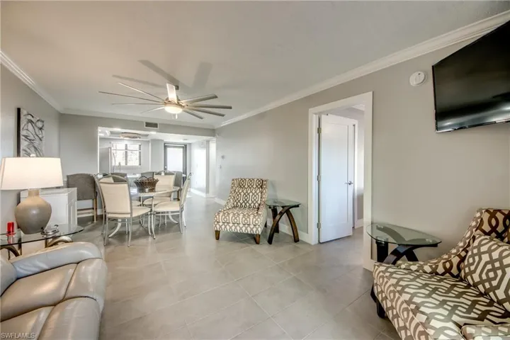 Living room featuring crown molding and ceiling fan