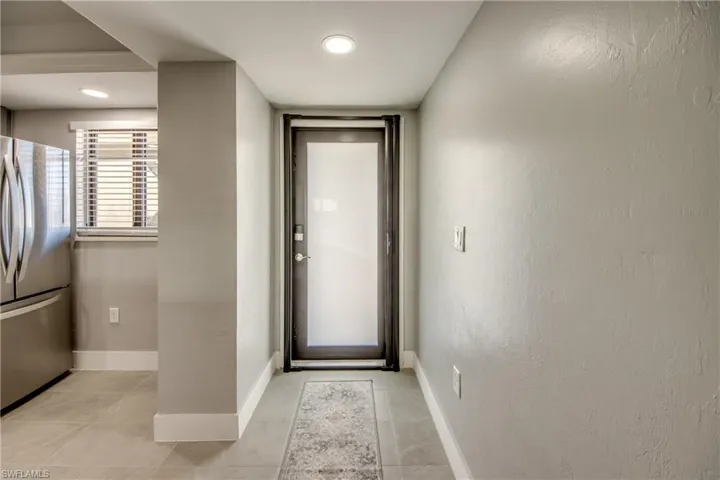 Entryway with a textured wall, tile patterned floors, and recessed lighting