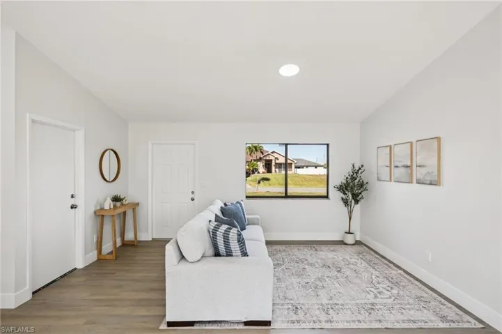 Sitting room featuring vaulted ceiling and wood finished floors