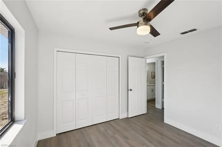 Unfurnished bedroom with wood finished floors, a ceiling fan, and a closet