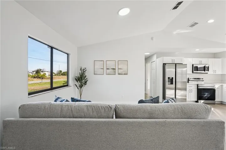 Living room with vaulted ceiling and recessed lighting
