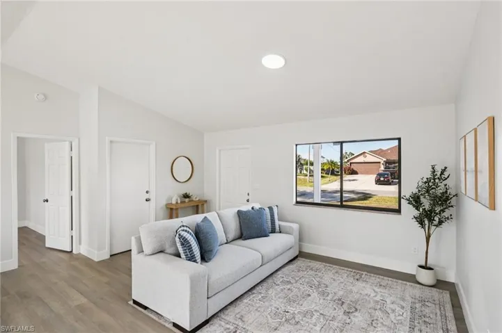 Living room with wood finished floors and vaulted ceiling