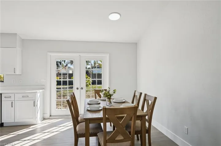 Dining space with french doors and dark wood-style floors