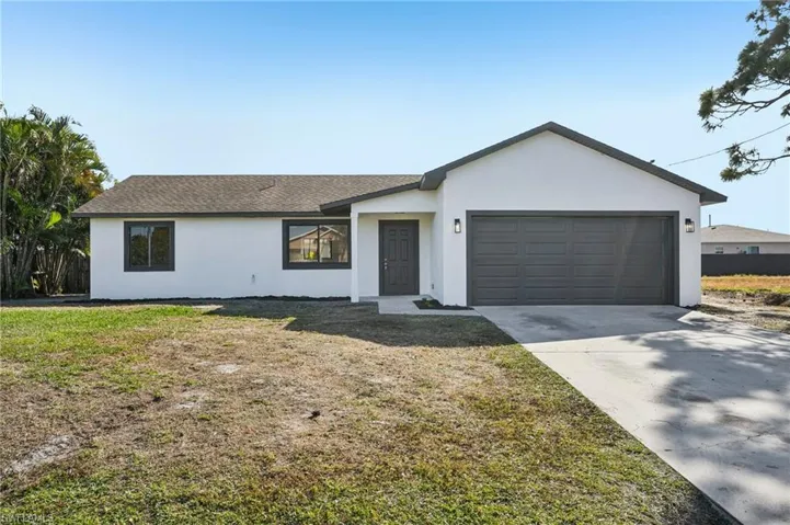 Single story home with stucco siding, driveway, a garage, and roof with shingles