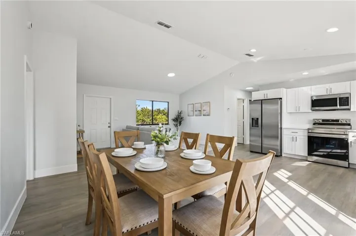 Dining room featuring light wood-style flooring, lofted ceiling, and recessed lighting