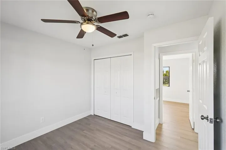 Unfurnished bedroom with wood finished floors, a closet, and ceiling fan