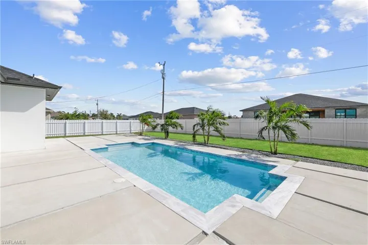 View of pool with a lawn and a patio area